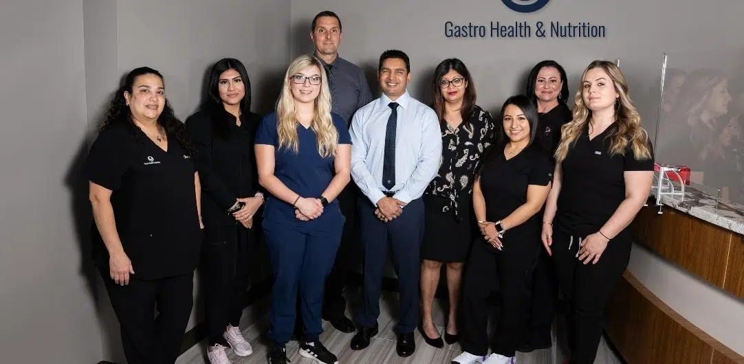 gastro-img Group of medical staff standing together in a clinic with 'Gastro Health & Nutrition' sign in the background.